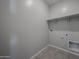 A functional laundry room with tile floors, neutral colored walls, and shelf at 2570 E Music Mountain Ave, Apache Junction, AZ 85119