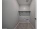 A functional laundry room with tile floors, neutral colored walls, and shelf at 2570 E Music Mountain Ave, Apache Junction, AZ 85119