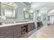 Bathroom with double sinks, decorative mirrors, and a sliding glass door to the bedroom at 2890 N 156Th Dr, Goodyear, AZ 85395