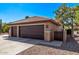 Attached two-car garage with stone accents and desert landscaping at 2890 N 156Th Dr, Goodyear, AZ 85395