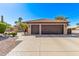 Attached two-car garage with stone accents, a clay tile roof, and wide driveway at 2890 N 156Th Dr, Goodyear, AZ 85395