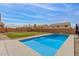 A view of the inground swimming pool, fire pit, and grassy backyard area at 29767 W Amelia Ave, Buckeye, AZ 85396