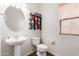 Half bathroom features pedestal sink, designer shelves, and bright natural light at 29767 W Amelia Ave, Buckeye, AZ 85396