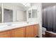 Bathroom featuring a double sink vanity and a shower with a curtain at 29767 W Amelia Ave, Buckeye, AZ 85396