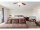 Well-lit bedroom with neutral color scheme, carpet, ceiling fan and ample natural light at 29767 W Amelia Ave, Buckeye, AZ 85396