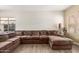 Relaxing living room with wood-look flooring, natural light, and a roomy sectional sofa at 29767 W Amelia Ave, Buckeye, AZ 85396