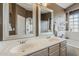 Bathroom featuring double vanity sinks, large mirrors, and tiled shower at 3116 W Folgers Rd, Phoenix, AZ 85027