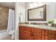 Bathroom featuring granite counters, a shower-tub combo, and a decorative mirror at 32 E Dawn Dr, Tempe, AZ 85284