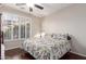 Bedroom featuring wood floors, plantation shutters, and a decorative ceiling fan at 3234 N 163Rd Dr, Goodyear, AZ 85395