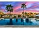 Backyard pool area with travertine deck, lounge chairs, and lush landscaping, creating a relaxing outdoor oasis at 3234 N 163Rd Dr, Goodyear, AZ 85395