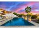 Backyard pool area with travertine deck, lounge chairs, and lush landscaping, creating a relaxing outdoor oasis at 3234 N 163Rd Dr, Goodyear, AZ 85395