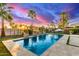 Backyard pool area with travertine deck, lounge chairs, and lush landscaping, creating a relaxing outdoor oasis at 3234 N 163Rd Dr, Goodyear, AZ 85395