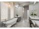 A serene bathroom featuring a standalone tub, statement chandelier, and stylish fixtures with ample natural light at 3373 E Oriole Way, Chandler, AZ 85286