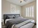 A modern bedroom with plantation shutters, neutral walls, and plenty of natural light with a ceiling fan at 3373 E Oriole Way, Chandler, AZ 85286