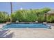 Stunning pool area with lush landscaping, stone accents, and a tranquil waterfall feature at 3373 E Oriole Way, Chandler, AZ 85286