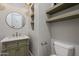 Stylish powder room featuring a round mirror, sage vanity, and built-in shelving for modern convenience at 3373 E Oriole Way, Chandler, AZ 85286