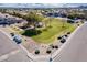 Aerial view of community park with green grass, playground, covered picnic, landscaping, and benches at 34969 N Open Range Dr, San Tan Valley, AZ 85144