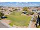 Aerial view of community park with lush green grass, playground, and a covered picnic area at 34969 N Open Range Dr, San Tan Valley, AZ 85144