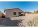 View of the cozy backyard with gravel landscaping and covered patio area with outdoor seating at 34969 N Open Range Dr, San Tan Valley, AZ 85144