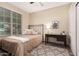 Cozy bedroom featuring an iron bed frame, a desk, and a large window for natural light at 34969 N Open Range Dr, San Tan Valley, AZ 85144