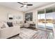 Bright living room with a large gray sectional, neutral decor, and modern wood-look floors at 34969 N Open Range Dr, San Tan Valley, AZ 85144