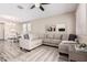 Bright living room with a large gray sectional, neutral decor, and modern wood-look floors at 34969 N Open Range Dr, San Tan Valley, AZ 85144