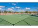 Community tennis court is surrounded by a fence and shrubbery and is perfect for friendly matches and exercise at 34969 N Open Range Dr, San Tan Valley, AZ 85144