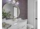 Stylish bathroom featuring a modern vanity, gold hardware, round mirror and patterned accent wall at 35150 N Bell Rd, Queen Creek, AZ 85144