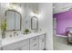 Elegant bathroom with dual sinks, gold fixtures, and stylish wallpaper, creating a luxurious atmosphere at 35150 N Bell Rd, Queen Creek, AZ 85144