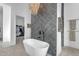 Luxurious bathroom featuring a standalone tub, modern tile, and a view into a walk-in closet at 35150 N Bell Rd, Queen Creek, AZ 85144