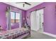 Cozy bedroom with purple walls, a unique metal-frame bed, and a sliding barn door to the ensuite bathroom at 35150 N Bell Rd, Queen Creek, AZ 85144