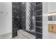 Modern shower with a black tiled shower with a built-in bench and mosaic tiled flooring at 35150 N Bell Rd, Queen Creek, AZ 85144