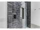 Contemporary shower with black tile, mosaic tile accent, and rainfall showerhead at 35150 N Bell Rd, Queen Creek, AZ 85144