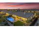 Aerial view of a backyard with a pool, spa, outdoor kitchen, and patio at dusk at 3547 E Bloomfield Pkwy, Gilbert, AZ 85296