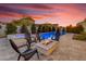 Inviting backyard with a relaxing pool, spa, seating area, and a warm fire pit under a colorful sunset sky at 3547 E Bloomfield Pkwy, Gilbert, AZ 85296