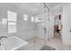 Bright bathroom featuring modern tub and glass shower, complemented by white tile and natural light at 3547 E Bloomfield Pkwy, Gilbert, AZ 85296