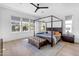 Elegant Primary bedroom with a four-poster bed and natural light from large windows at 3547 E Bloomfield Pkwy, Gilbert, AZ 85296