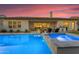 Beautiful backyard pool and spa at twilight, complemented by an outdoor kitchen and covered patio space at 3547 E Bloomfield Pkwy, Gilbert, AZ 85296