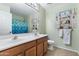 Bright bathroom featuring a framed mirror, dual sinks, and blue shower curtain at 3663 E Camden Ave, San Tan Valley, AZ 85140