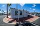 The exterior of this manufactured home boasts a corner lot and vibrant palm trees at 39 Iron Ore Dr, Apache Junction, AZ 85119