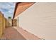 View of backyard featuring painted brick walls, wooden gate, and red brick flooring at 5125 W Las Palmaritas Dr, Glendale, AZ 85302