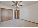 Bedroom features a ceiling fan, closet with wood doors, and neutral carpeting at 5125 W Las Palmaritas Dr, Glendale, AZ 85302