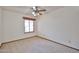 Bedroom with neutral carpet, a ceiling fan, and a large window at 5125 W Las Palmaritas Dr, Glendale, AZ 85302