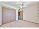 Bedroom with a ceiling fan, plush carpeting and a large closet space for storage at 5125 W Las Palmaritas Dr, Glendale, AZ 85302