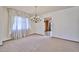 Formal dining room featuring classic chandelier and large window with decorative curtains at 5125 W Las Palmaritas Dr, Glendale, AZ 85302