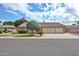 Charming single-story home with a well-manicured lawn, brick accents, and a three-car garage at 5125 W Las Palmaritas Dr, Glendale, AZ 85302