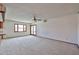 Spacious living room with plush carpeting, natural light, and a ceiling fan for added comfort at 5125 W Las Palmaritas Dr, Glendale, AZ 85302