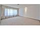 Living room featuring neutral carpet and large windows with decorative curtains at 5125 W Las Palmaritas Dr, Glendale, AZ 85302