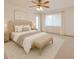 Neutral-toned main bedroom has a large window, ceiling fan, and offers a spacious, relaxing retreat at 5125 W Las Palmaritas Dr, Glendale, AZ 85302