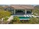 Relaxing backyard pool area with lounge chairs, covered patio, and lush landscaping at 5142 N 205Th Gln, Buckeye, AZ 85396